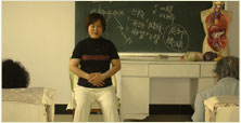 Liu Yafei, the 7th successor of Nei Yang Gong Qigong and Vice Director of the Beidaihe Medical Qigong hospital guiding patients in the practice of Jing Gong
